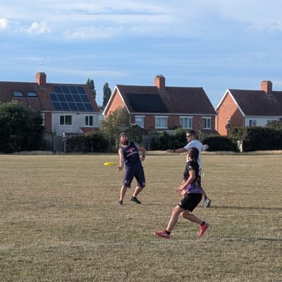 A Wyverns player about to release a throw on an outdoor pitch while closely marked by a defender