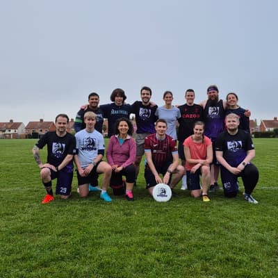 Wyverns players group photo on an outdoor grass pitch after a match against visiting teams, under an overcast sky
